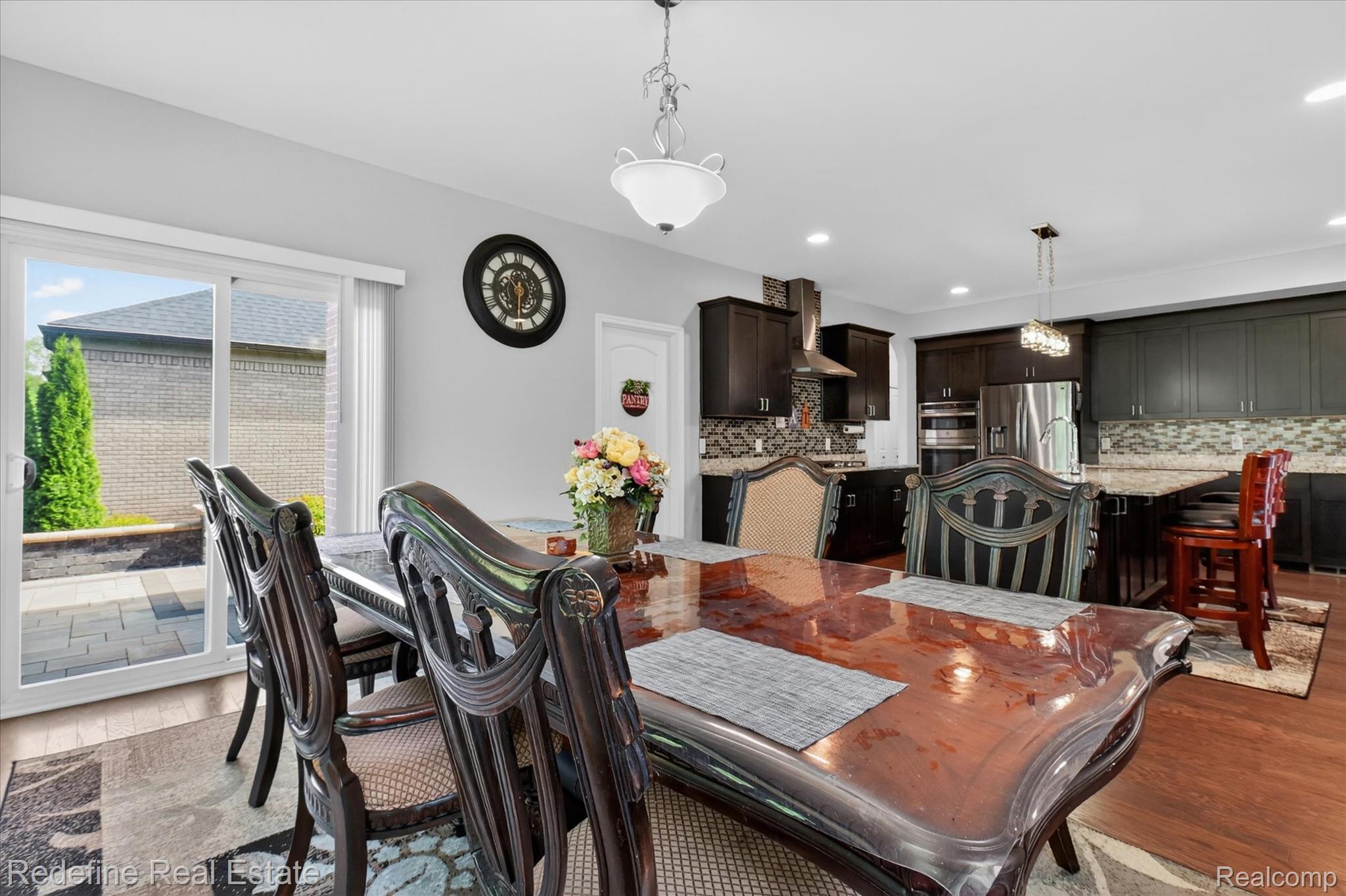 2976 Andlaur Drive Rochester, MI 48307 - Photo 16 of 60 Spacious dining area with wood-finish flooring, featuring a sliding glass door opening to a paver patio