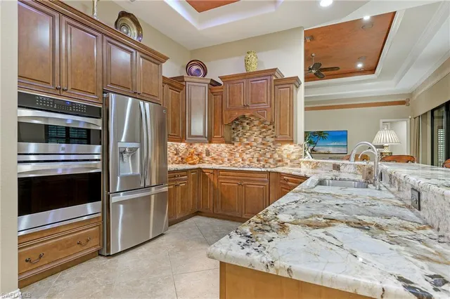 a kitchen with stainless steel appliances kitchen island granite countertop a refrigerator and cabinets