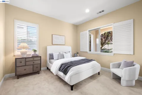 a spacious bathroom with a tub double vanity and windows