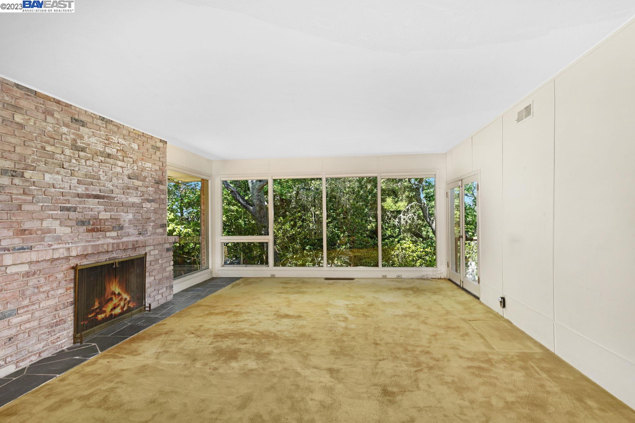 Undisclosed Address Orinda, CA 94563 - Photo 6 of 32 a view of an empty room with a fireplace and a window