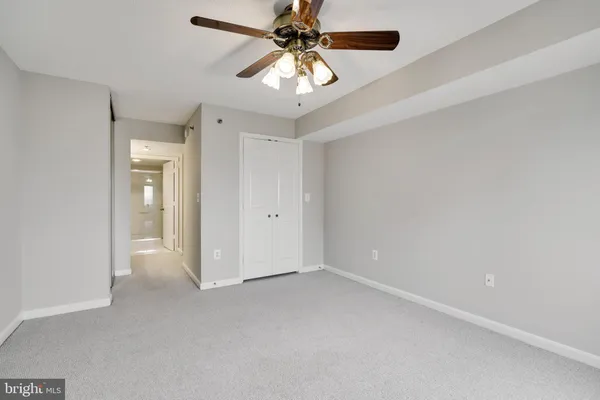 an empty room with chandelier fan