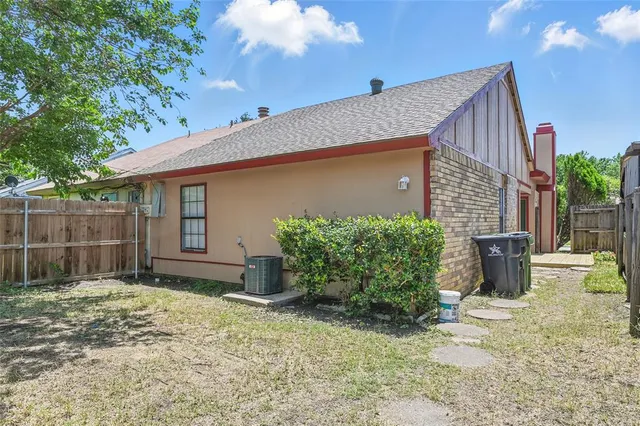 a backyard of a house with potted plants and large tree