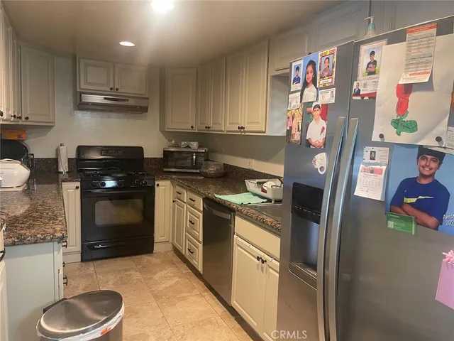 a kitchen with stainless steel appliances granite countertop a stove a sink and a refrigerator