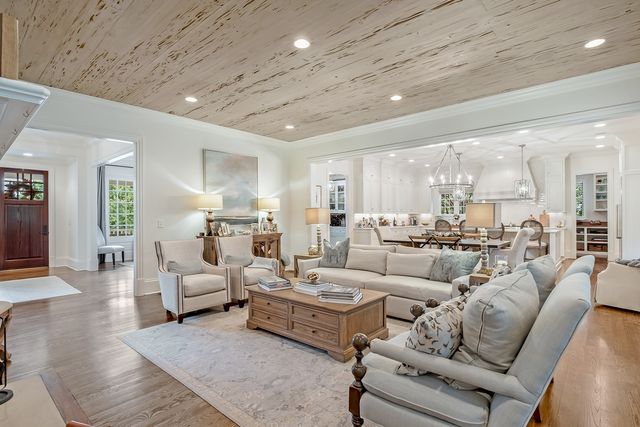 a view of a dining room with furniture a chandelier and wooden floor