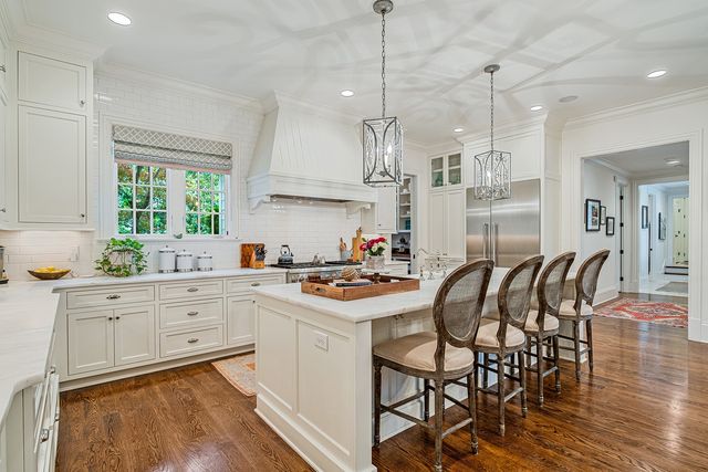 a kitchen with kitchen island granite countertop a sink a center island a counter space and wooden floor
