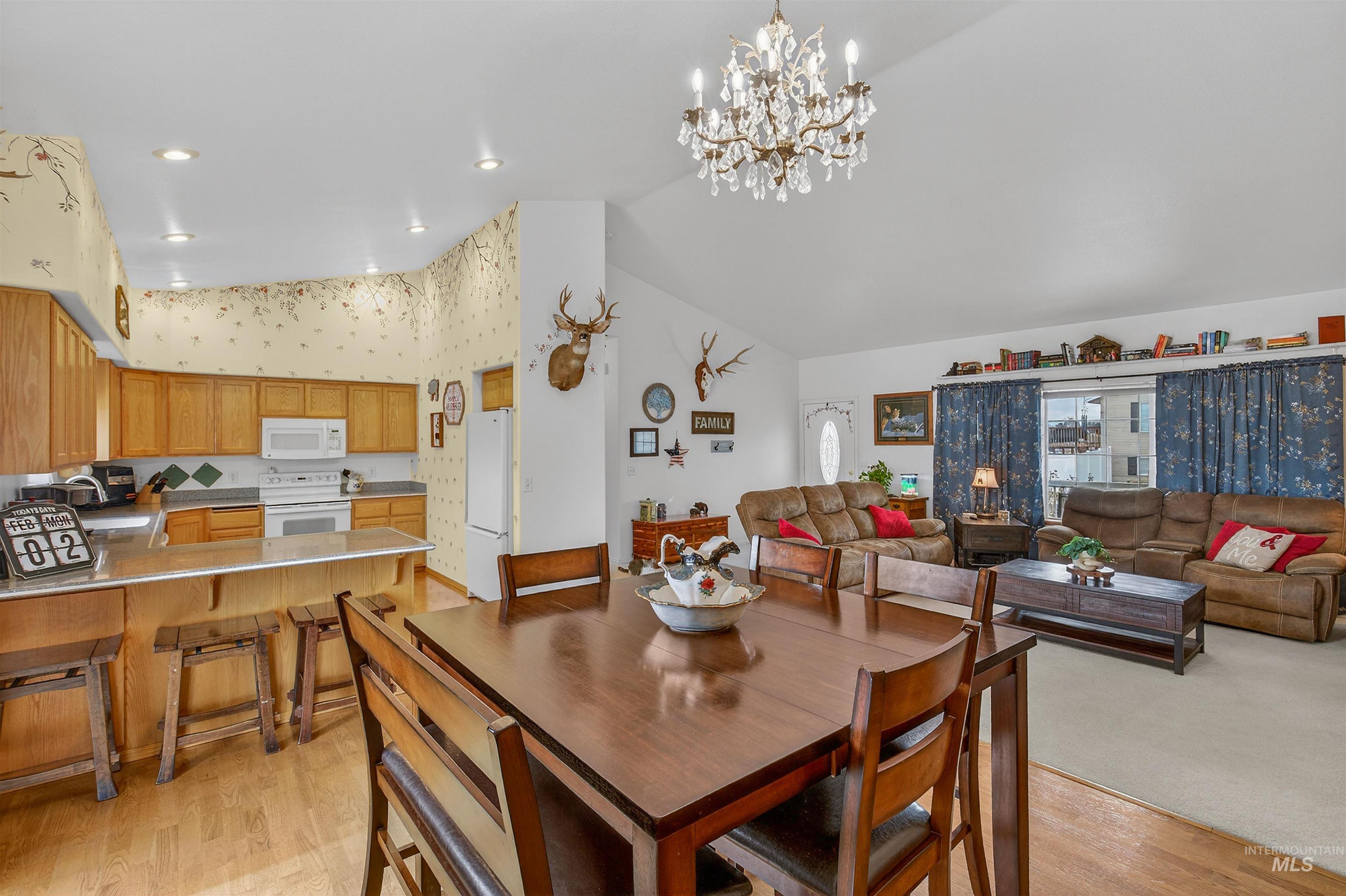 3737 19th Street Lewiston, ID 83501 - Photo 12 of 40 Dining room featuring vaulted ceiling, light wood finished floors, suspended lighting, and wallpapered walls