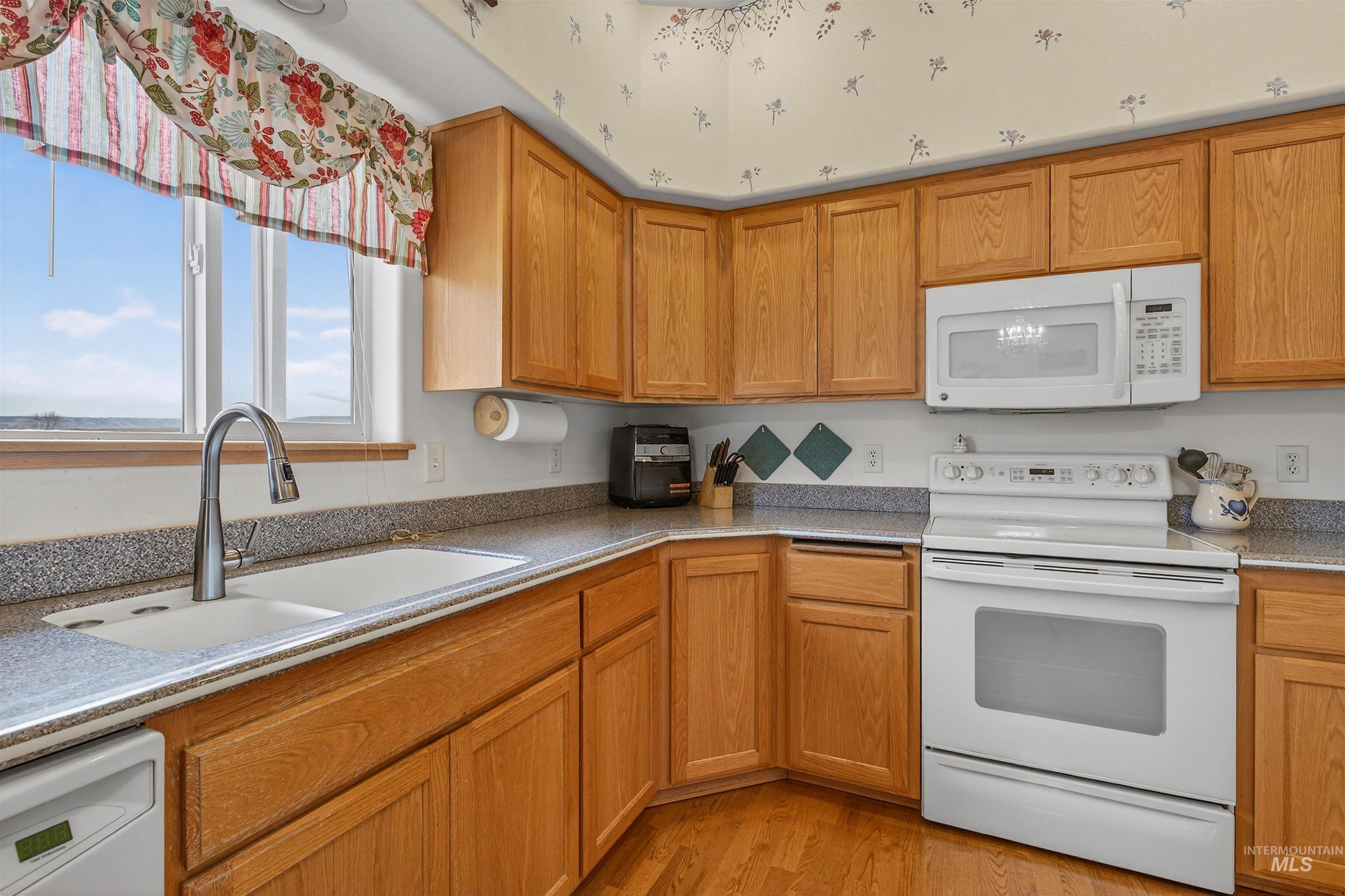 3737 19th Street Lewiston, ID 83501 - Photo 15 of 40 Kitchen with white appliances, light stone counters, wood finish cabinets, and light wood-type flooring
