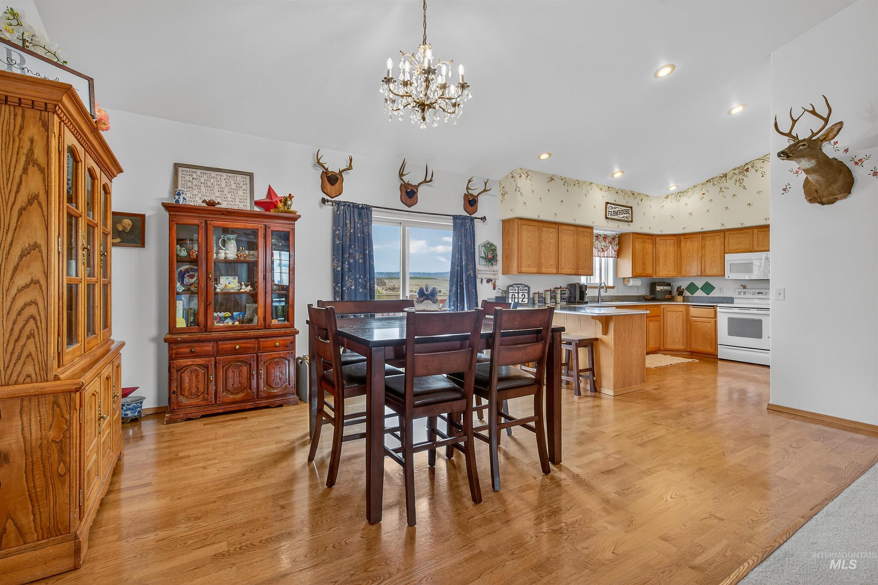 3737 19th Street Lewiston, ID 83501 - Photo 10 of 40 Dining area featuring lofted ceiling, a chandelier, light wood finished floors, and plenty of natural light