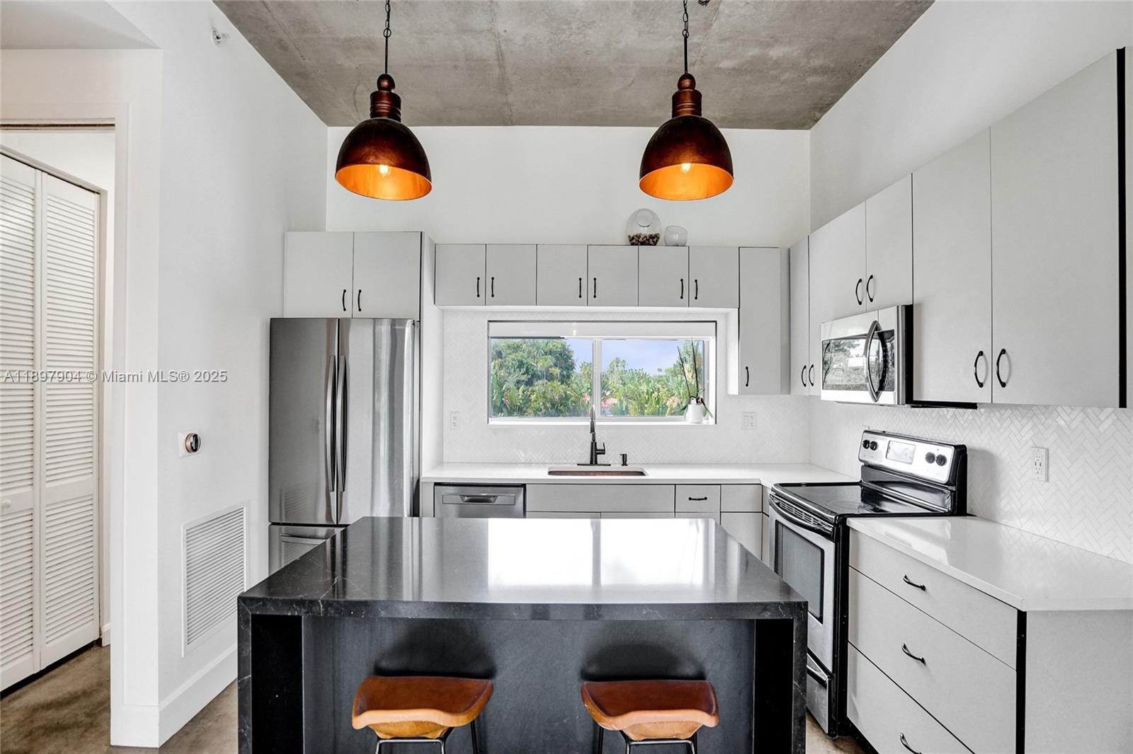 716 Southeast 12th Street, Unit 13 Fort Lauderdale, FL 33316 - Photo 18 of 45 a kitchen with stainless steel appliances granite countertop a stove a sink a refrigerator and a window