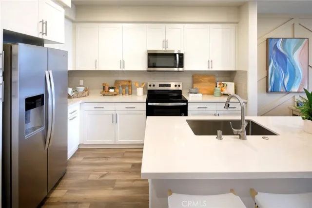 a kitchen with stainless steel appliances kitchen island granite countertop a refrigerator stove and sink