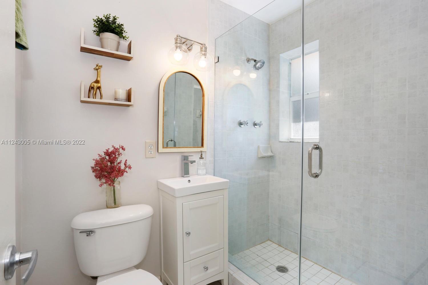 6310 Southwest 79th Street, Unit 18 South Miami, FL 33143 - Photo 12 of 16 a bathroom with a toilet sink and shower