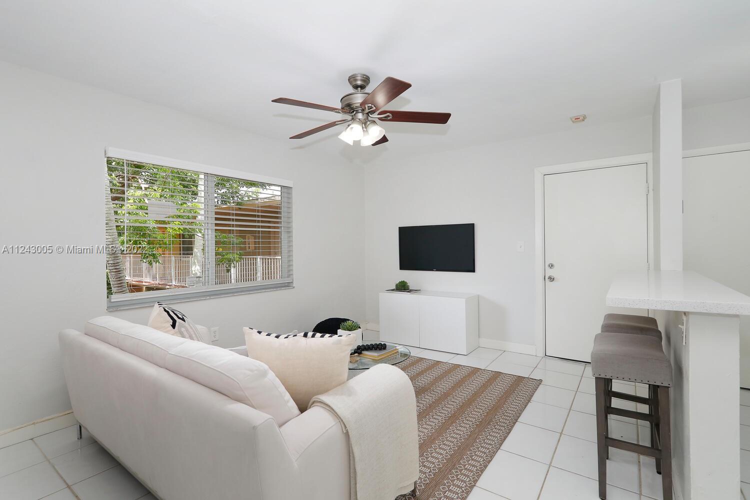 6310 Southwest 79th Street, Unit 18 South Miami, FL 33143 - Photo 2 of 16 a living room with furniture and a flat screen tv