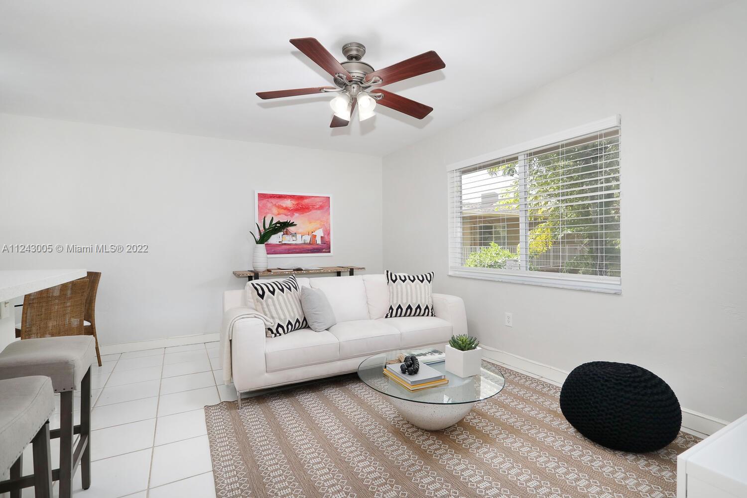 6310 Southwest 79th Street, Unit 18 South Miami, FL 33143 - Photo 3 of 16 a living room with furniture and a large window