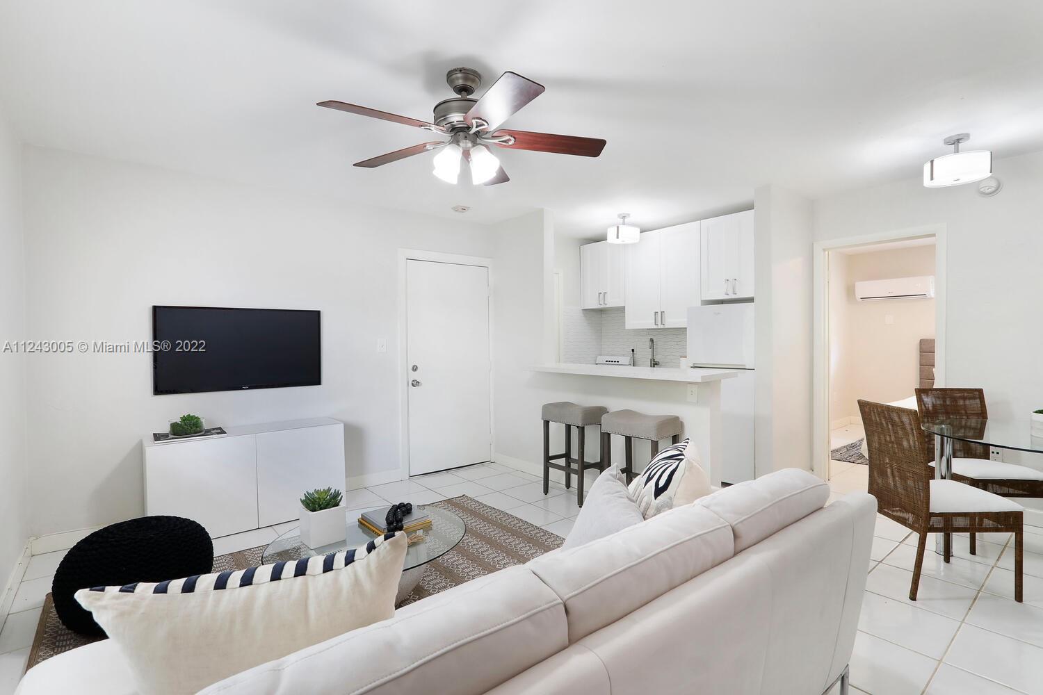 6310 Southwest 79th Street, Unit 18 South Miami, FL 33143 - Photo 4 of 16 a living room with furniture and a flat screen tv