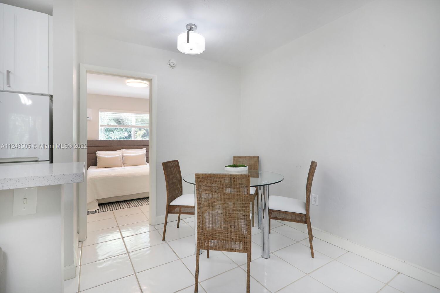 6310 Southwest 79th Street, Unit 18 South Miami, FL 33143 - Photo 5 of 16 a dining room with furniture and a window