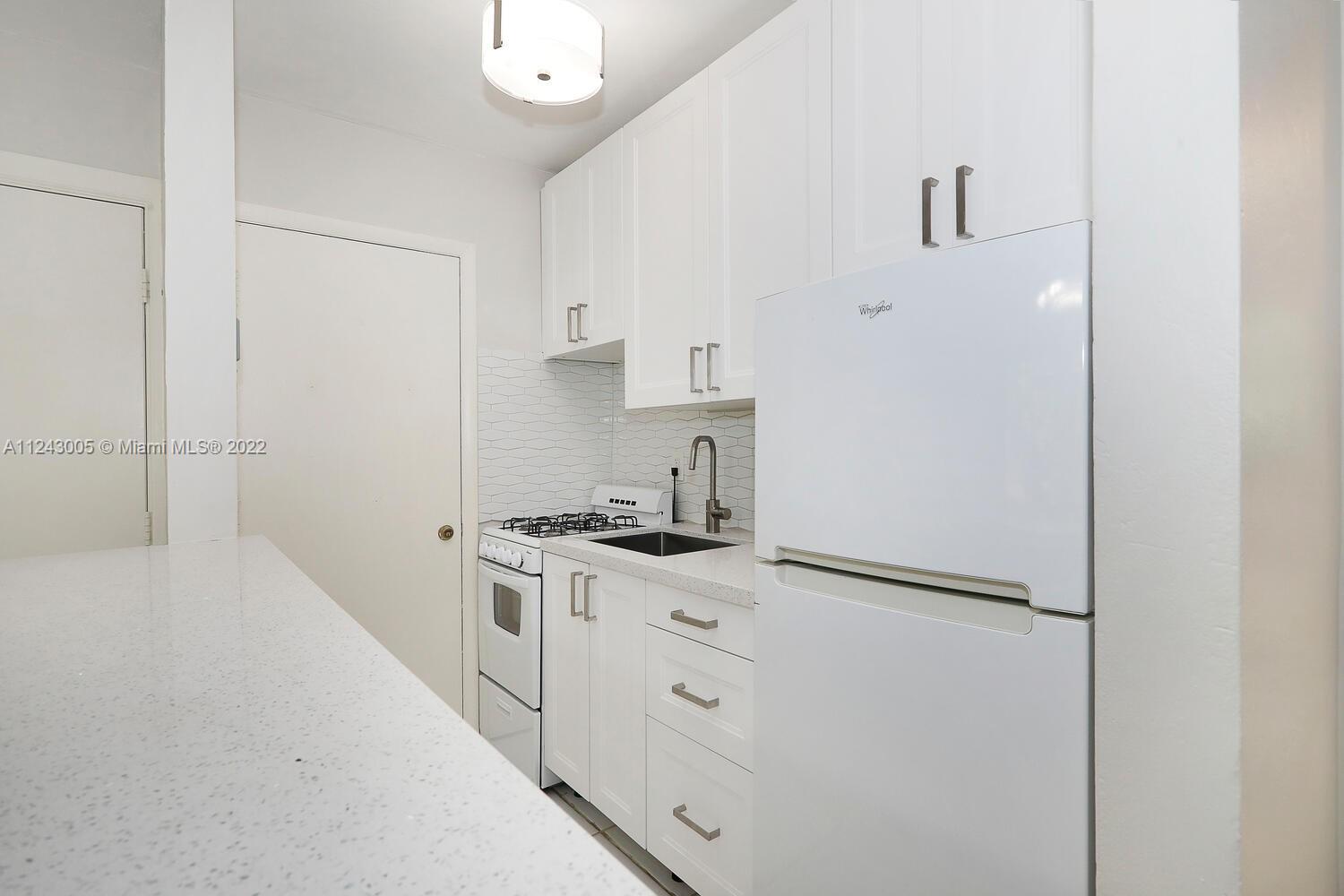 6310 Southwest 79th Street, Unit 18 South Miami, FL 33143 - Photo 8 of 16 a kitchen with white cabinets and white appliances