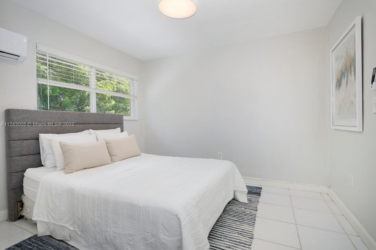 6310 Southwest 79th Street, Unit 18 South Miami, FL 33143 - Photo 10 of 16 a bedroom with a bed and a window