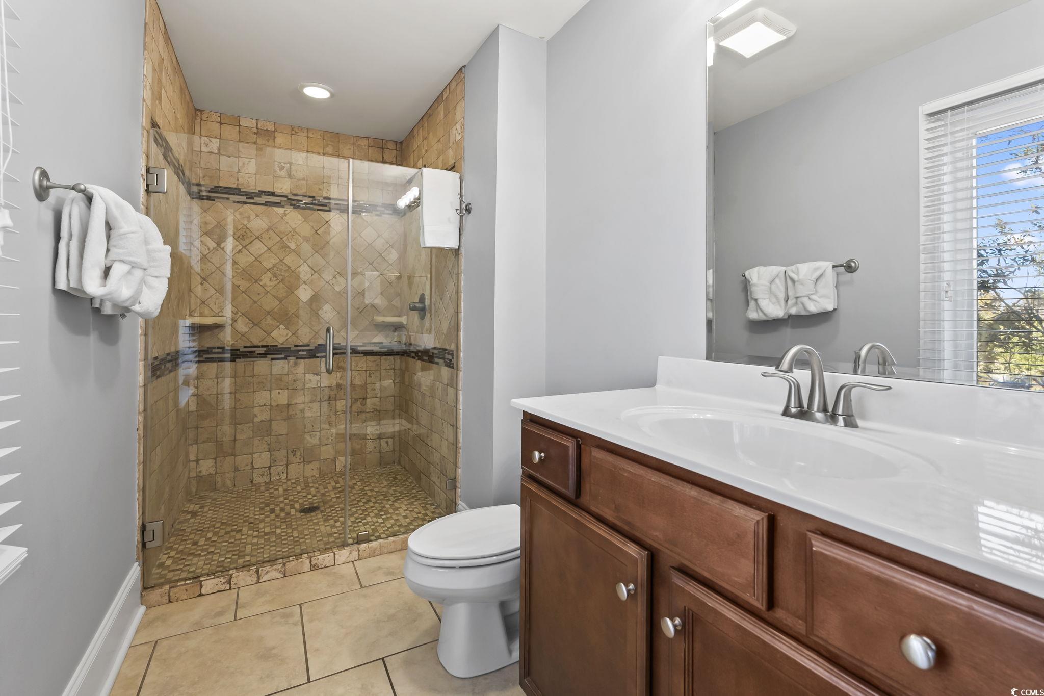 7401 North Ocean Boulevard, Unit 5 Myrtle Beach, SC 29572 - Photo 19 of 34 Bathroom featuring vanity, light tile patterned floors, and a shower stall