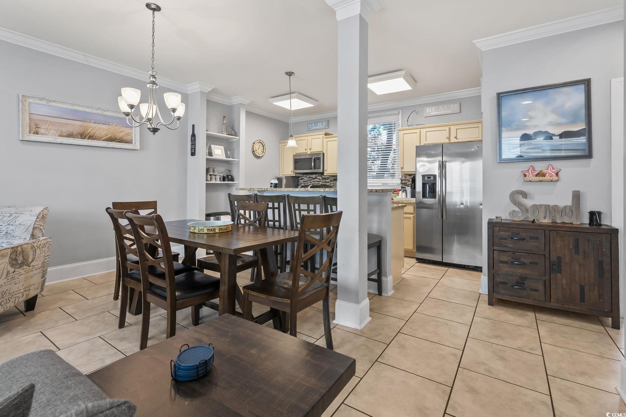 7401 North Ocean Boulevard, Unit 5 Myrtle Beach, SC 29572 - Photo 4 of 34 Dining area featuring light tile patterned floors, crown molding, and a chandelier