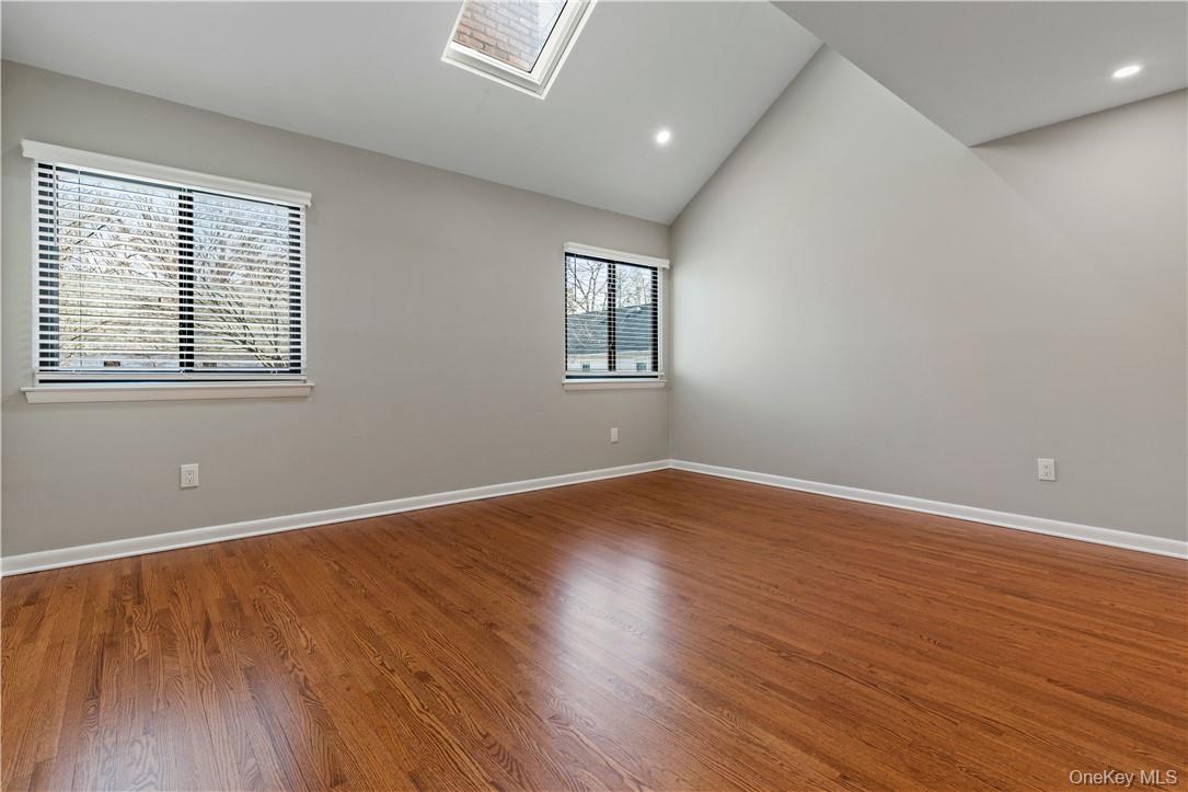 50 Pondview Road, Unit F Rye, NY 10580 - Photo 13 of 25 an empty room with wooden floor and windows