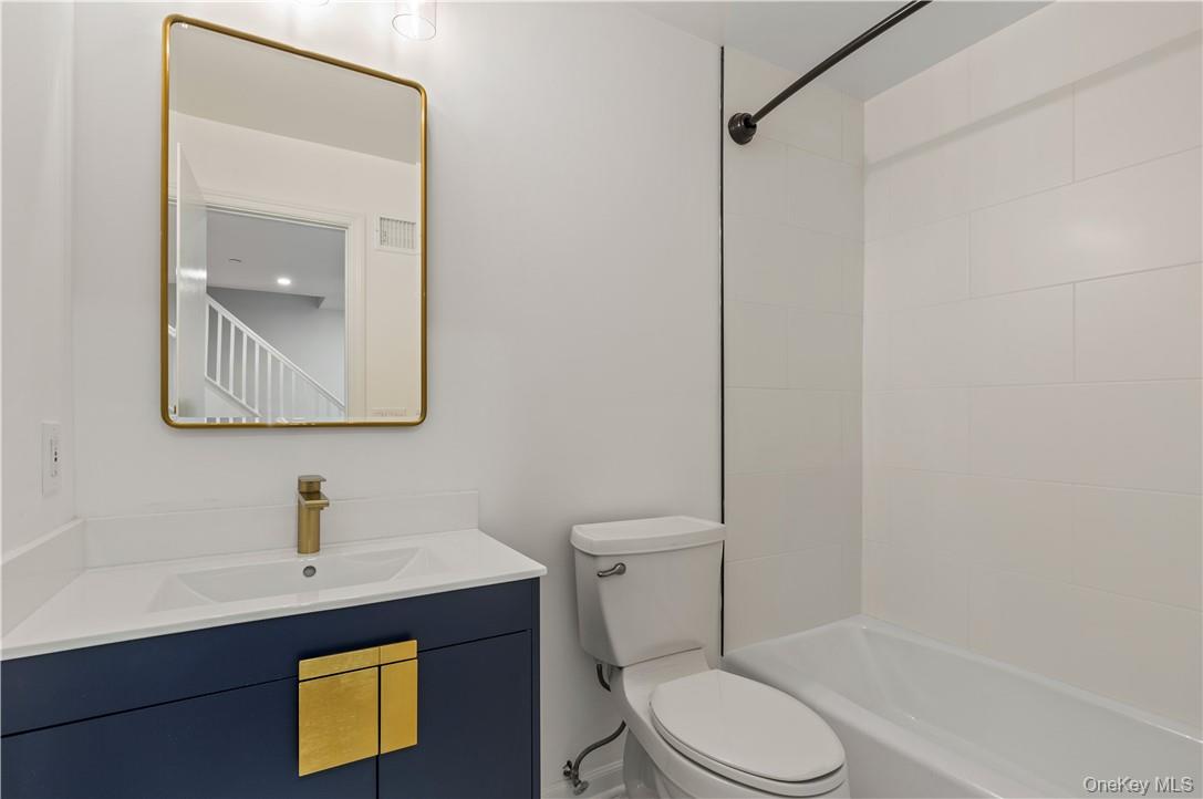 50 Pondview Road, Unit F Rye, NY 10580 - Photo 17 of 25 a bathroom with a toilet sink vanity and mirror