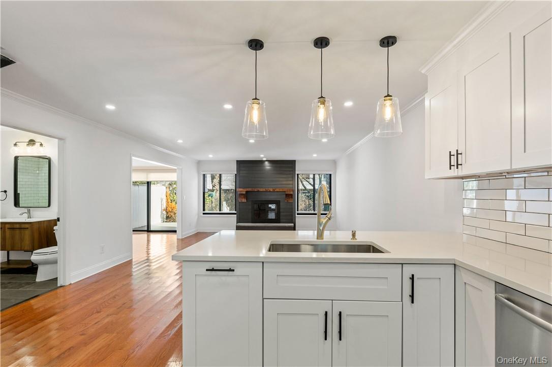 50 Pondview Road, Unit F Rye, NY 10580 - Photo 5 of 25 a kitchen with kitchen island granite countertop a sink a counter top space appliances and cabinets