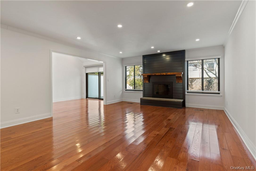 50 Pondview Road, Unit F Rye, NY 10580 - Photo 8 of 25 an empty room with wooden floor fireplace and windows