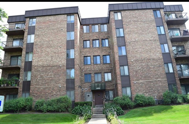 430 Walnut Creek Road, Unit 2306 Lisle, IL 60532 - Photo 1 of 14 a brick building with a yard in front of it