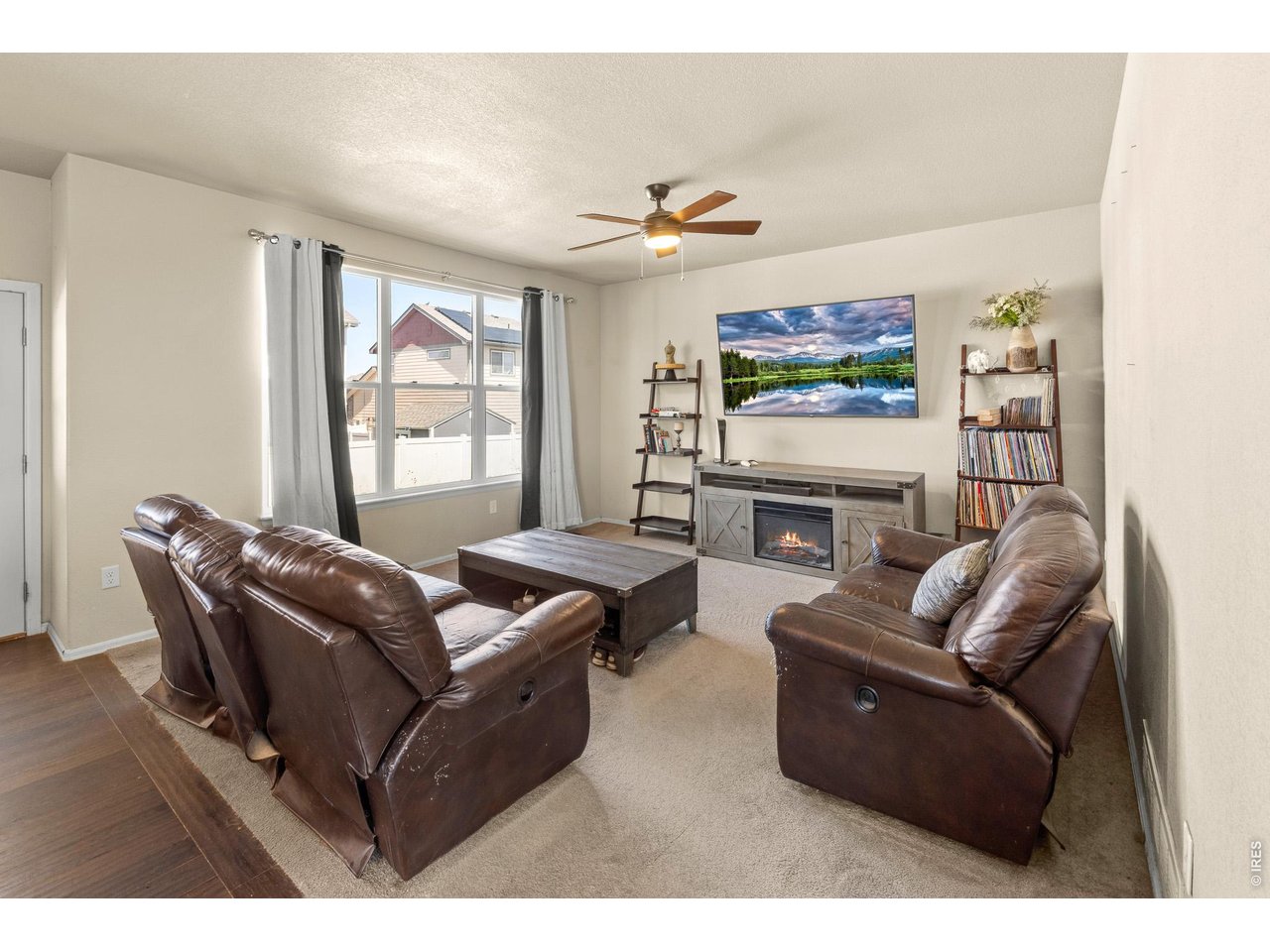 8847 16th St Road Greeley, CO 80634 - Photo 9 of 38 a living room with furniture a flat screen tv and a fireplace