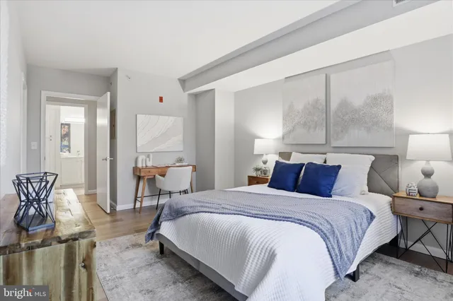 a bedroom with a bed a table and chair with the potted plant