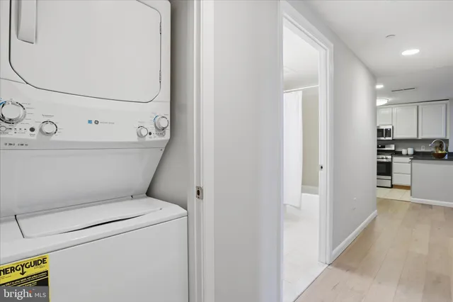 a view of washer and dryer with bathroom in the background