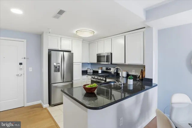 a kitchen with stainless steel appliances granite countertop a refrigerator a stove a sink a stove and island