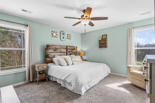 a bedroom with a bed a couch and a window