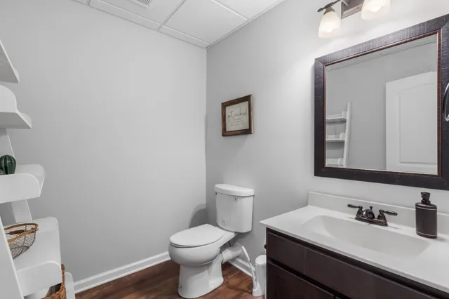a bathroom with a toilet sink vanity granite and mirror
