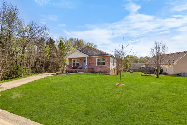 a house with green field in front of it