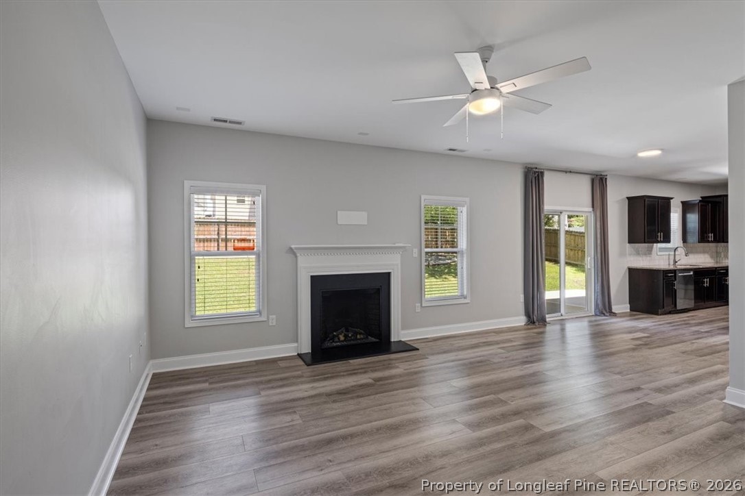 134 Huzzas Circle Cameron, NC 28326 - Photo 11 of 31 an empty room with wooden floor a fireplace and windows