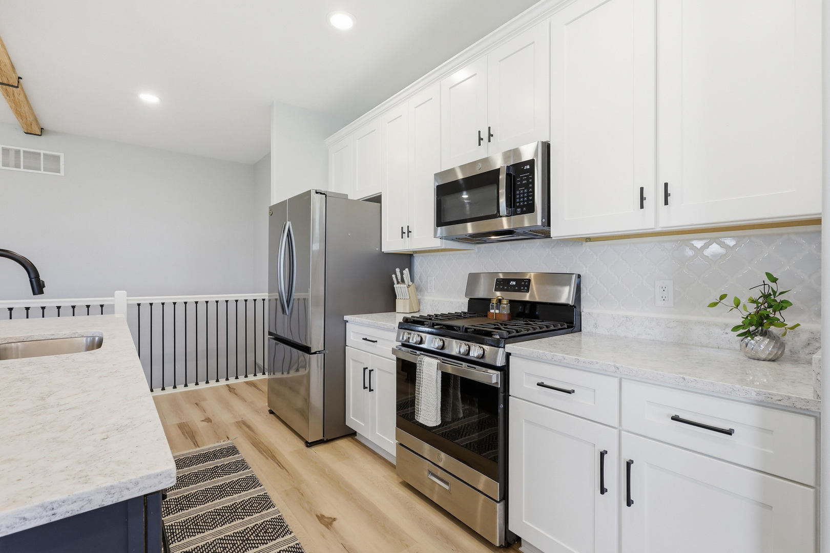 6779 Genesis Way Bettendorf, IA 52722 - Photo 10 of 36 a kitchen with stainless steel appliances white cabinets a stove a sink and a refrigerator