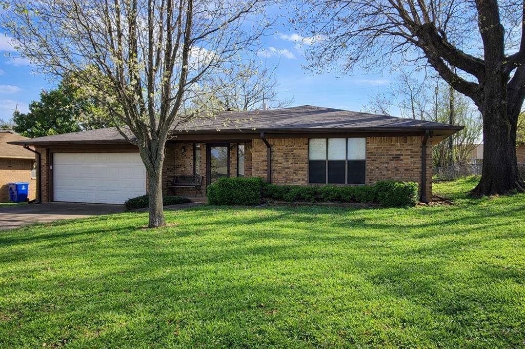 2302 Shiloh Street Denison, TX 75020 - Photo 2 of 16 a backyard of a house with plants and large tree