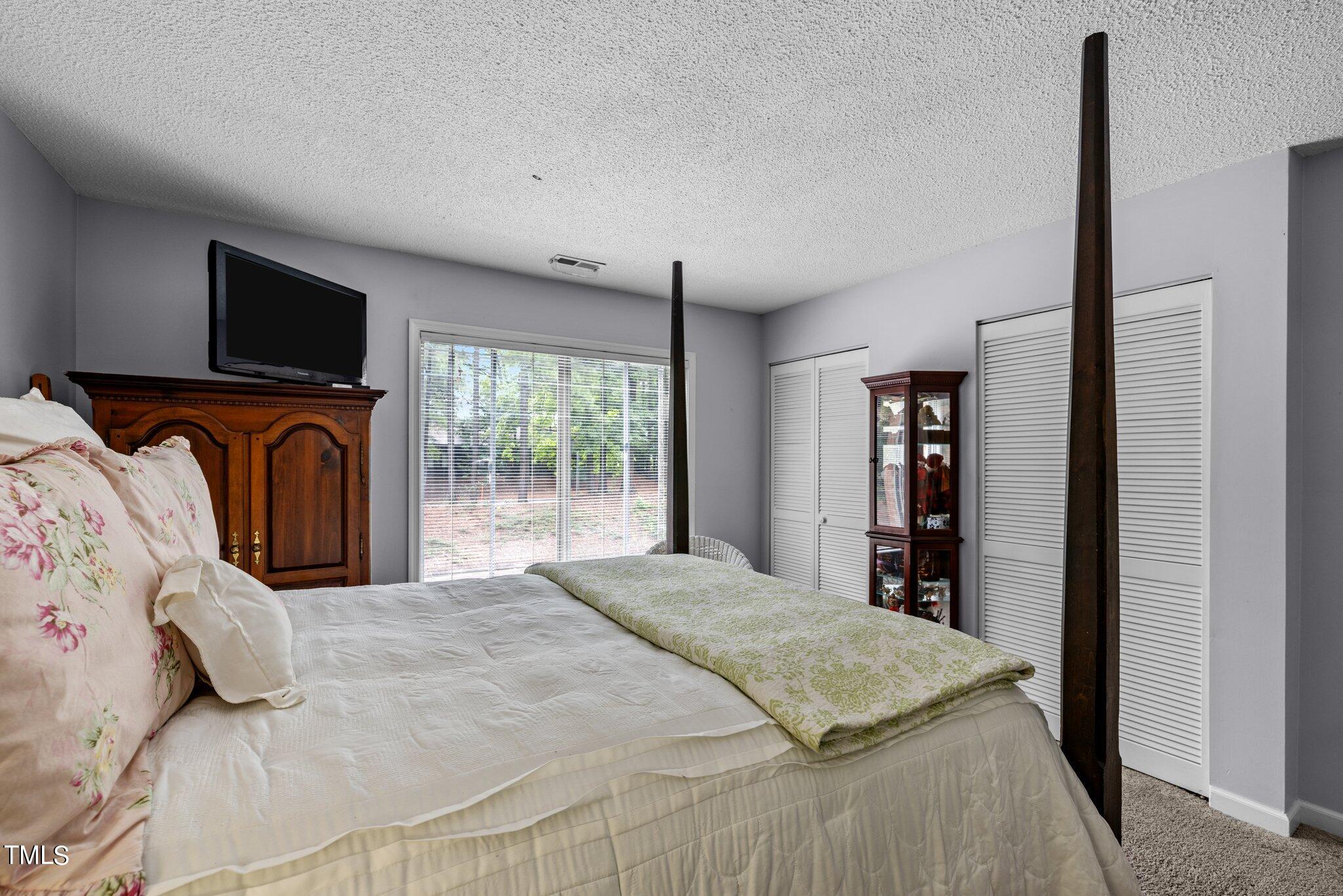 1917 Front Street, Unit 4C Durham, NC 27705 - Photo 32 of 53 a bedroom with a large bed and a flat tv screen