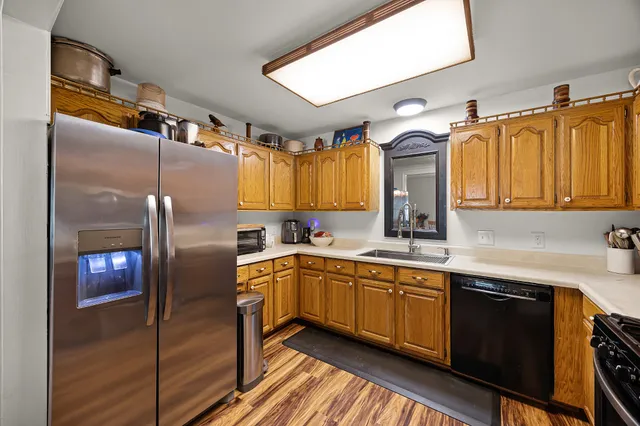 a kitchen with stainless steel appliances granite countertop a sink and a refrigerator