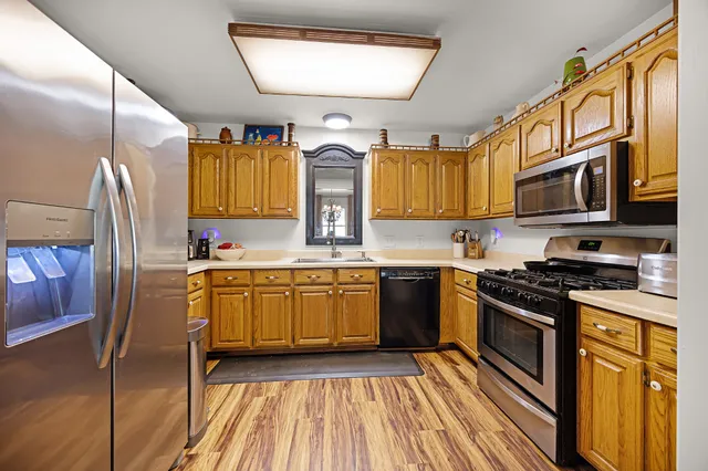 a kitchen with stainless steel appliances granite countertop a stove a sink and a microwave