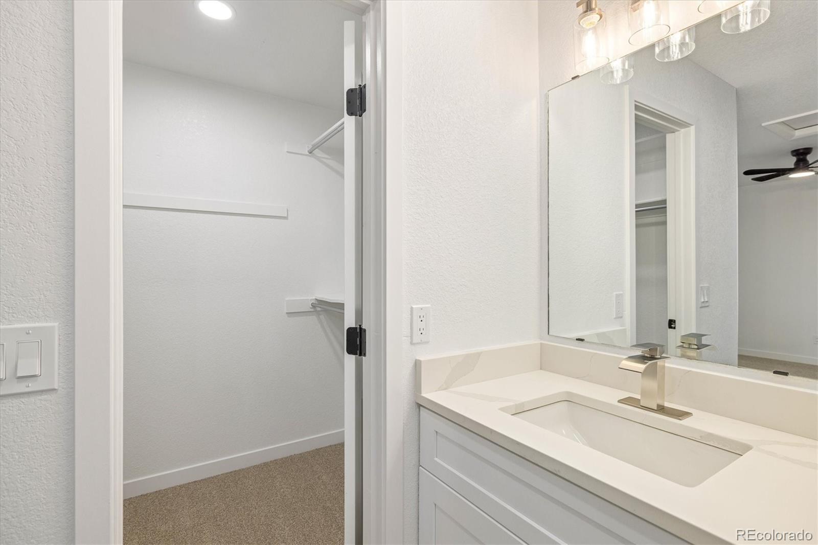 8612 Carr Loop Arvada, CO 80005 - Photo 13 of 35 a bathroom with a granite countertop sink and a mirror