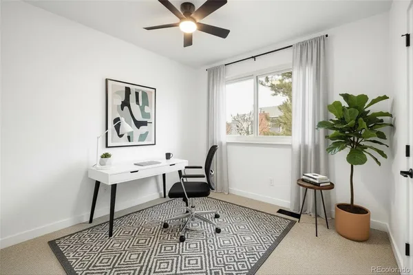 an empty room with a window and ceiling fan