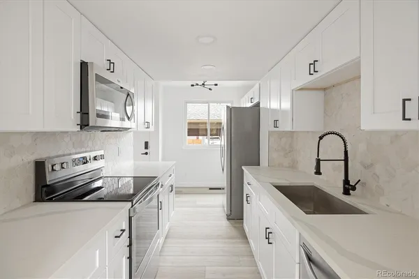 a kitchen with stainless steel appliances a sink stove and refrigerator