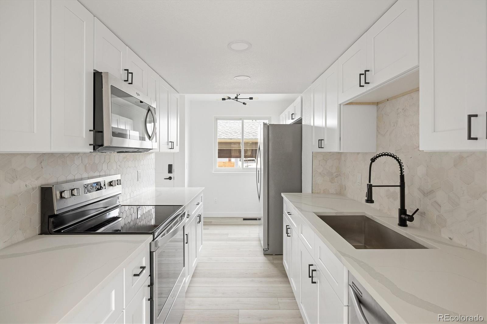 8612 Carr Loop Arvada, CO 80005 - Photo 9 of 35 a kitchen with stainless steel appliances a sink stove and refrigerator