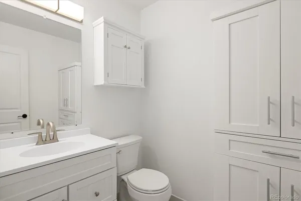 a bathroom with a sink a toilet and vanity