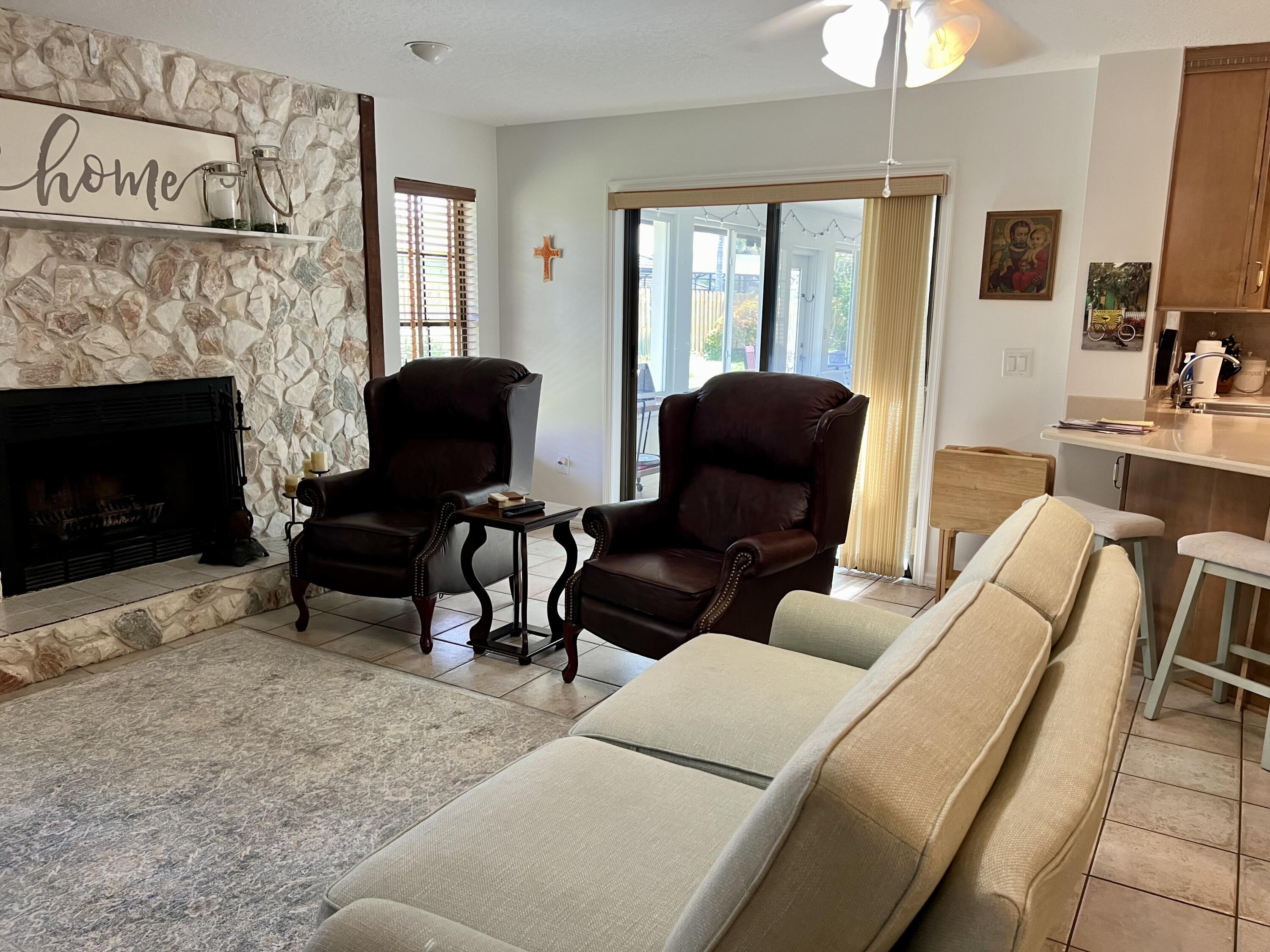 410 Rio Casa Drive South Indialantic, FL 32903 - Photo 19 of 25 a living room with furniture a fireplace and a flat screen tv