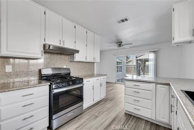 a kitchen with granite countertop a stove and a sink