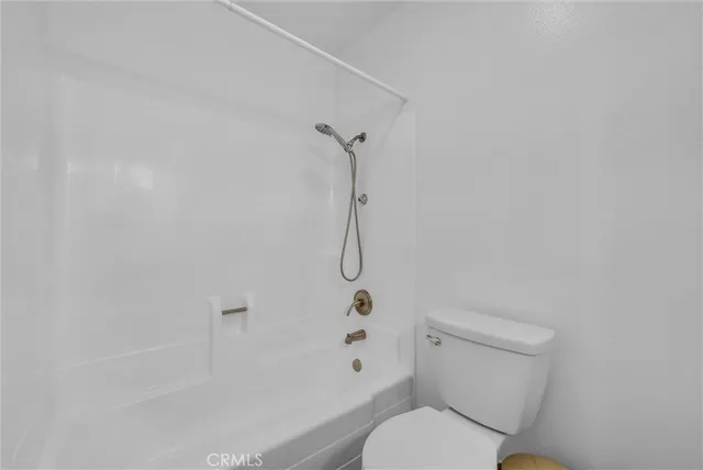 a white toilet sitting next to a bath tub