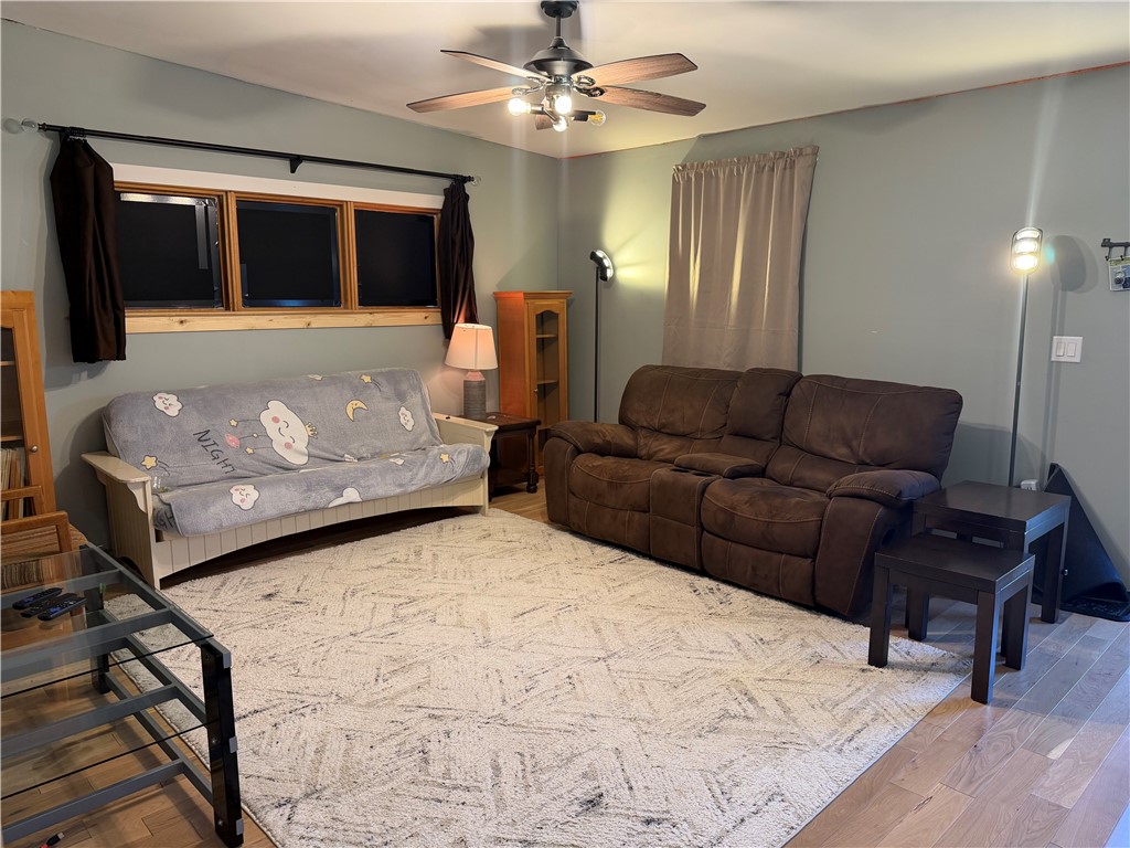 707 South Spring Street Walhalla, SC 29691 - Photo 6 of 20 This living room features rich wood flooring, natural light, and a functional ceiling fan for comfort.
